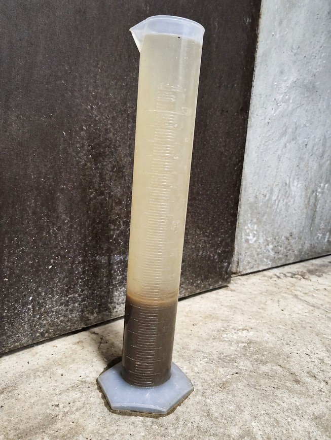 A wastewater sample in a graduated cylinder for observation of settling condition.